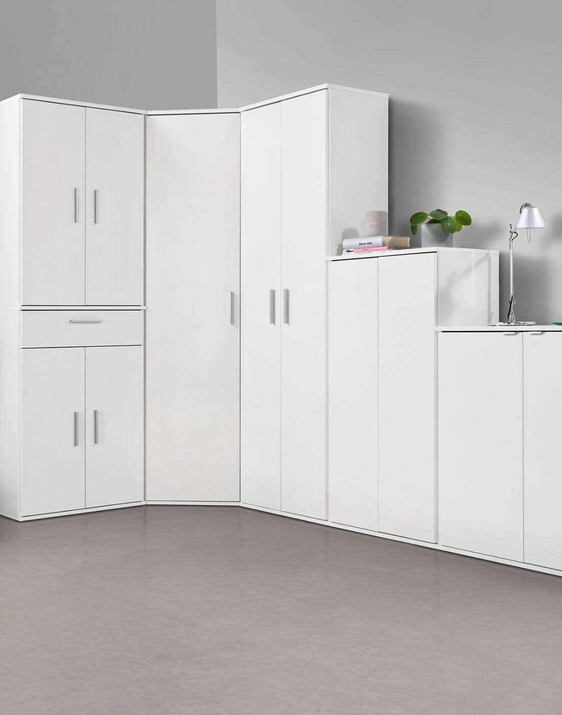 Schrankwand, verschiedene Mehrzweckschränke in weiß nebeneinander in einer Raumecke. Alle Schränke sind zu