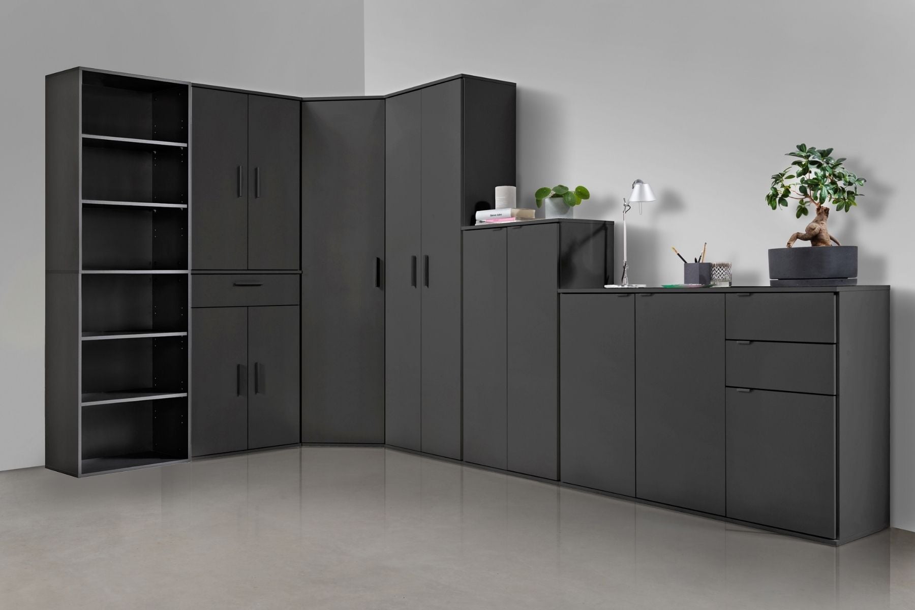 verschiedene Mehrzweckschränke in schwarz nebeneinander in einer Raumecke.