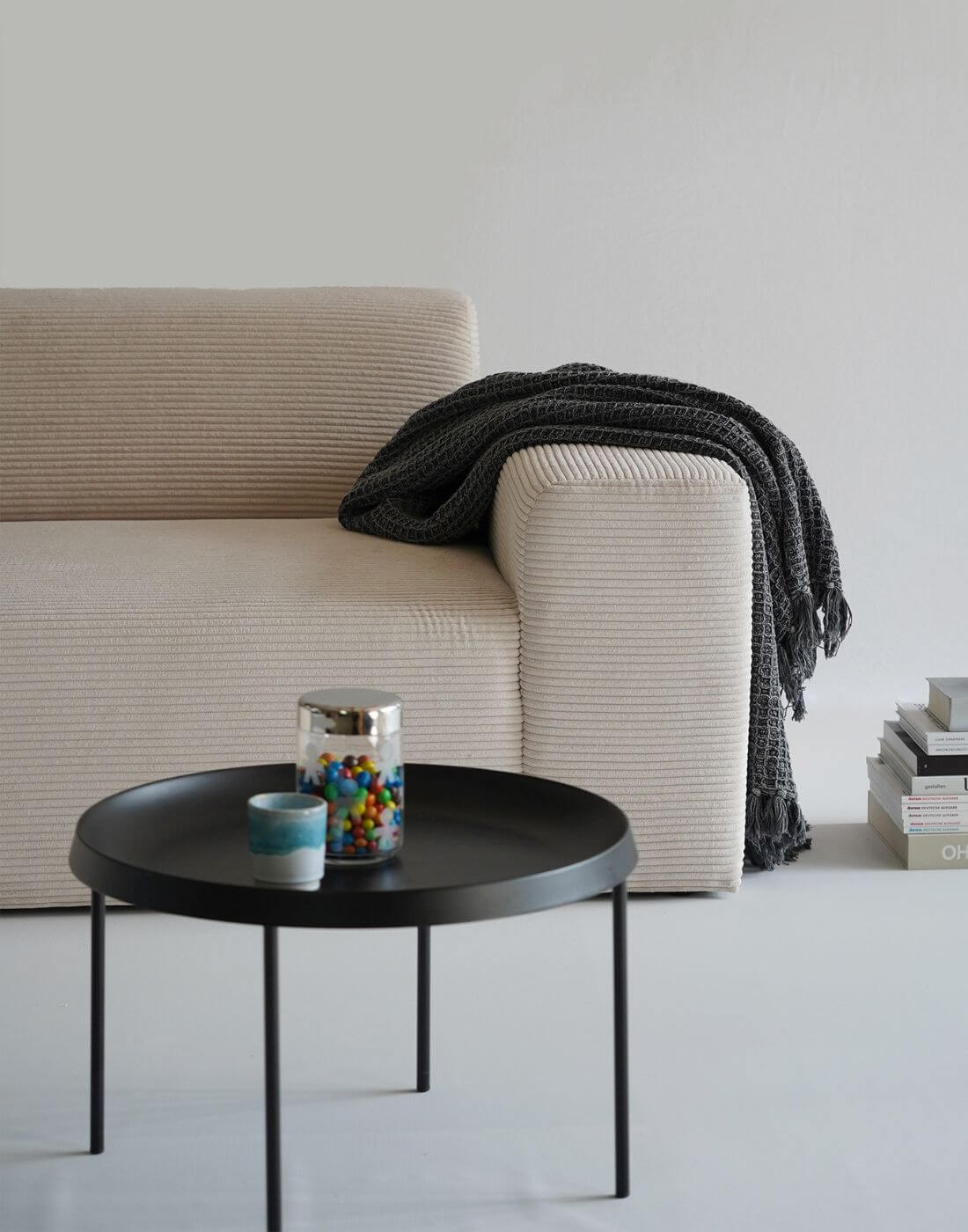 Cordsofa Armlehne, graue Decke liegt über der Armlehnen