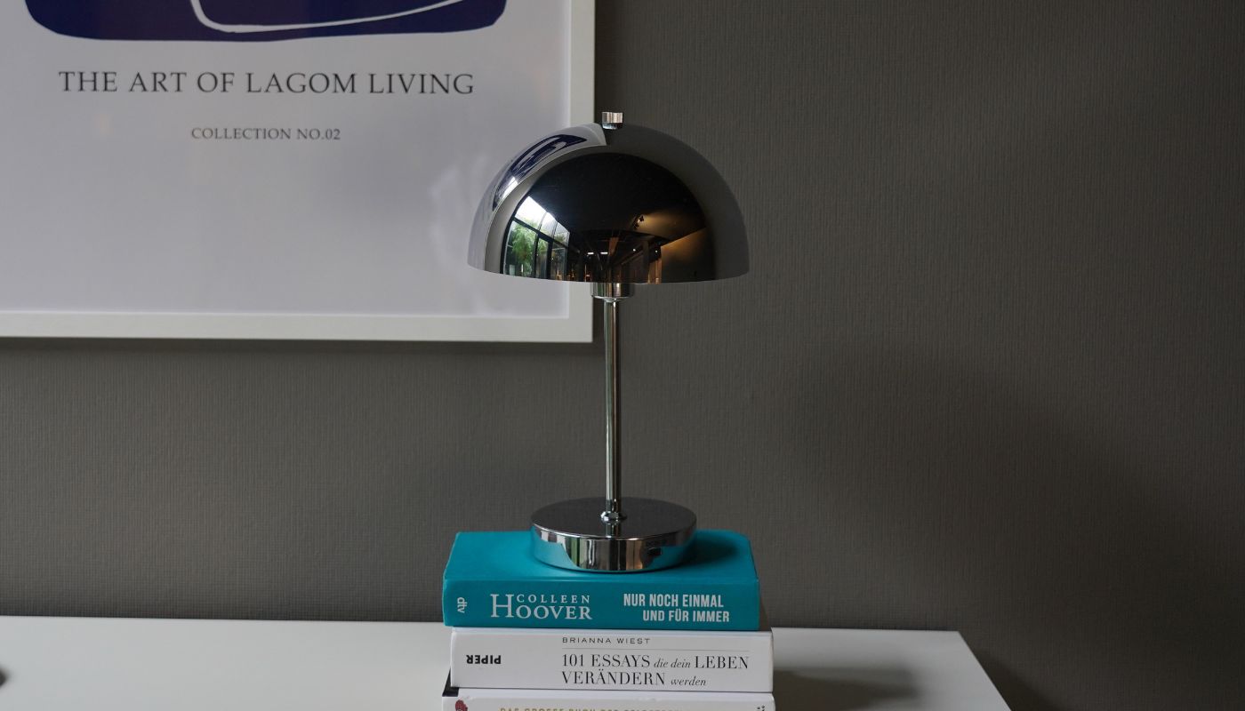 Chrom kabellose LED Tischlampe auf einem Bücherstapel 