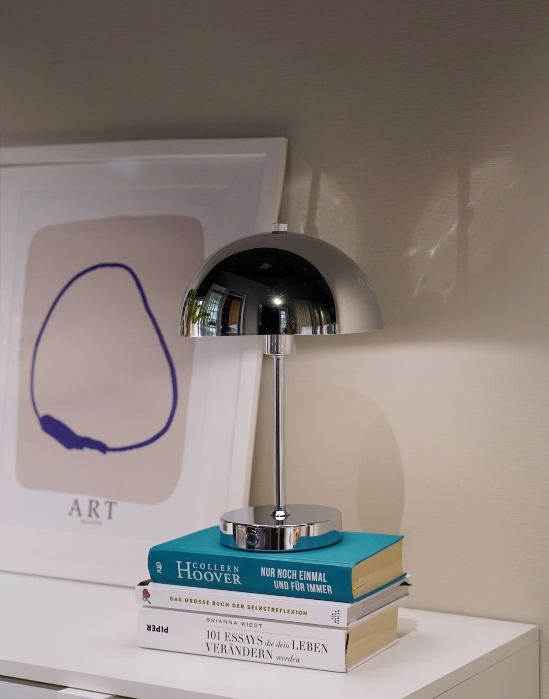 Chrom kabellose LED Tischlampe auf einem Bücherstapel 