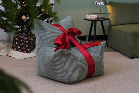 Kindersitzsack verpackt als Geschenk unter dem Weihnachtsbaum