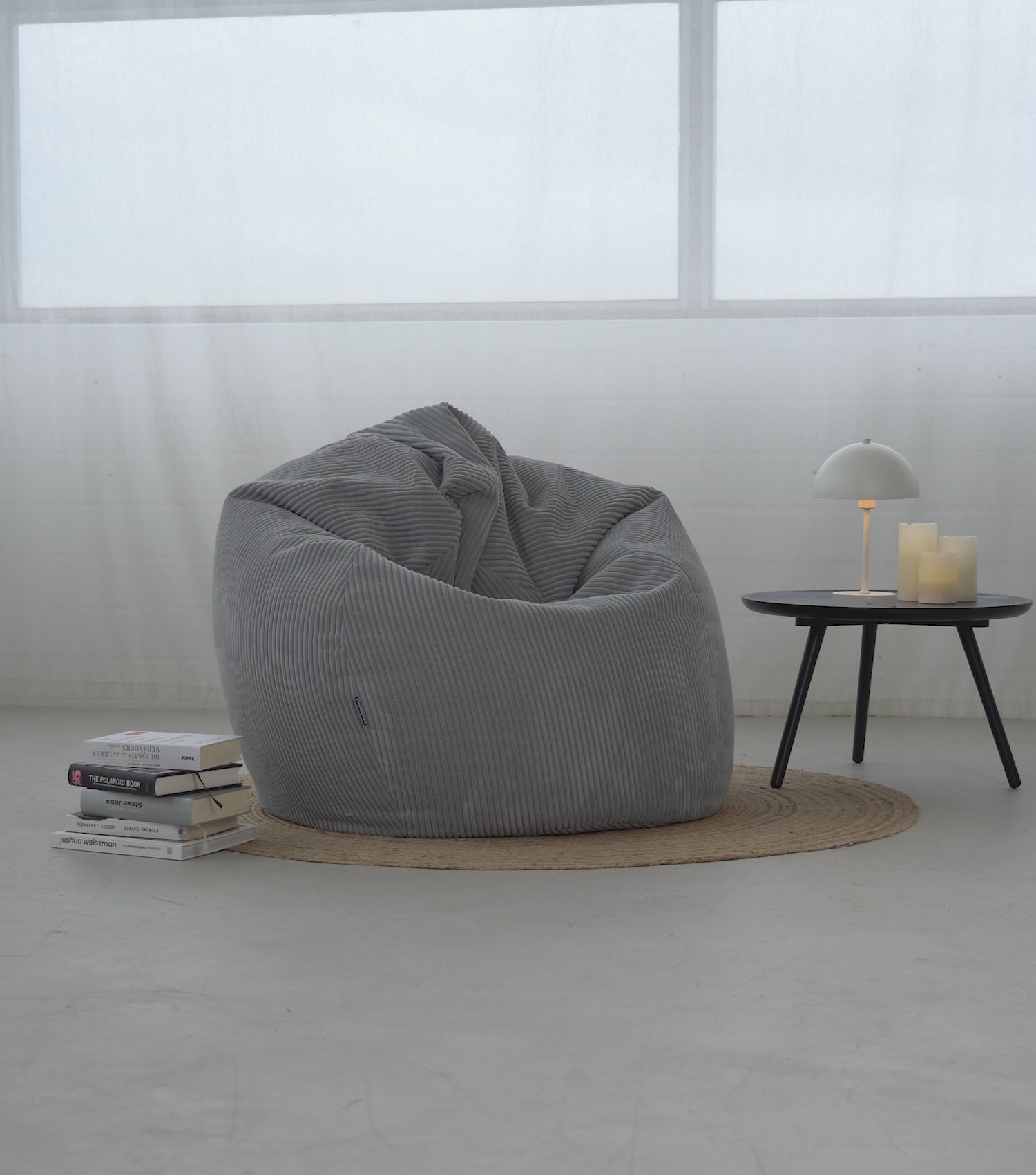 Produktvideo Sitzsack Sitzsessel 'Der Tagträumer' aus Cord in hellgrau. Mann setzt sich auf den Sitzsack, scrollt am Handy und streicht über den Stoff. Mann steht auf und trägt den Sitzsack aus dem Bild. 