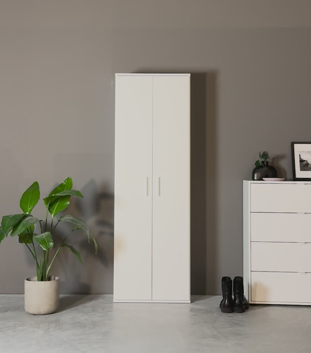 Produktvideo Mehrzweckschrank Garderobenschrank weiß mit Jacken, Taschen und Schuhen drin. Ein Paar Schuhe und eine Tasche werden hineingelegt. Eine Jacke wird in den Schrank aufgehängt. 